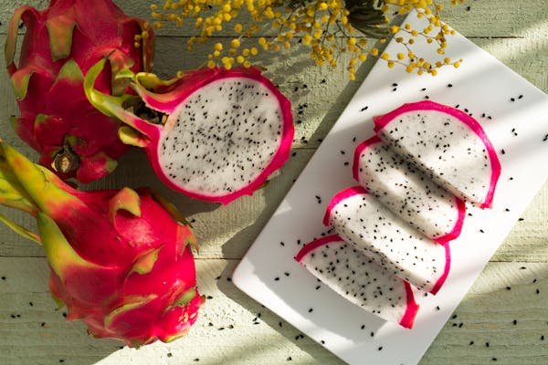 A vibrant assortment of dragon fruits, including yellow dragon fruit, red dragon, pink dragon fruit, and white dragon fruit, showcasing their colorful skins and fleshy interiors. Learn if this exotic fruit is safe for dogs.